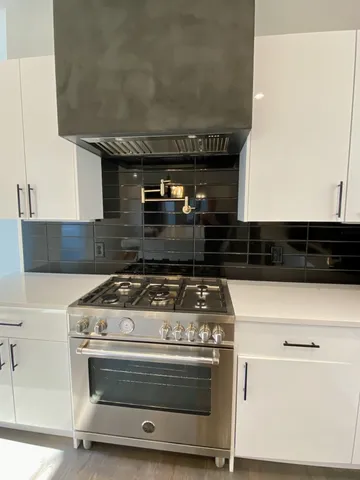 a stove top oven sitting inside of a kitchen