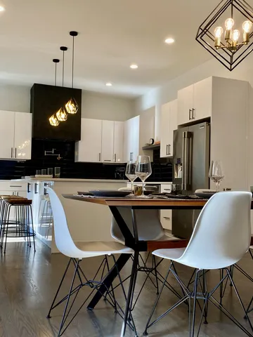 a kitchen with a dining table chairs and refrigerator