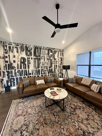 a living room with furniture a rug and a flat screen tv