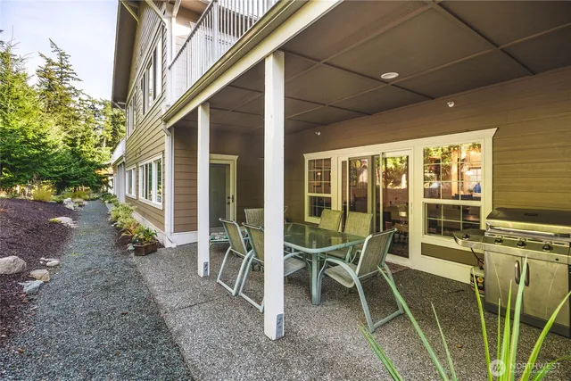 a porch with a table and chairs and wooden fence