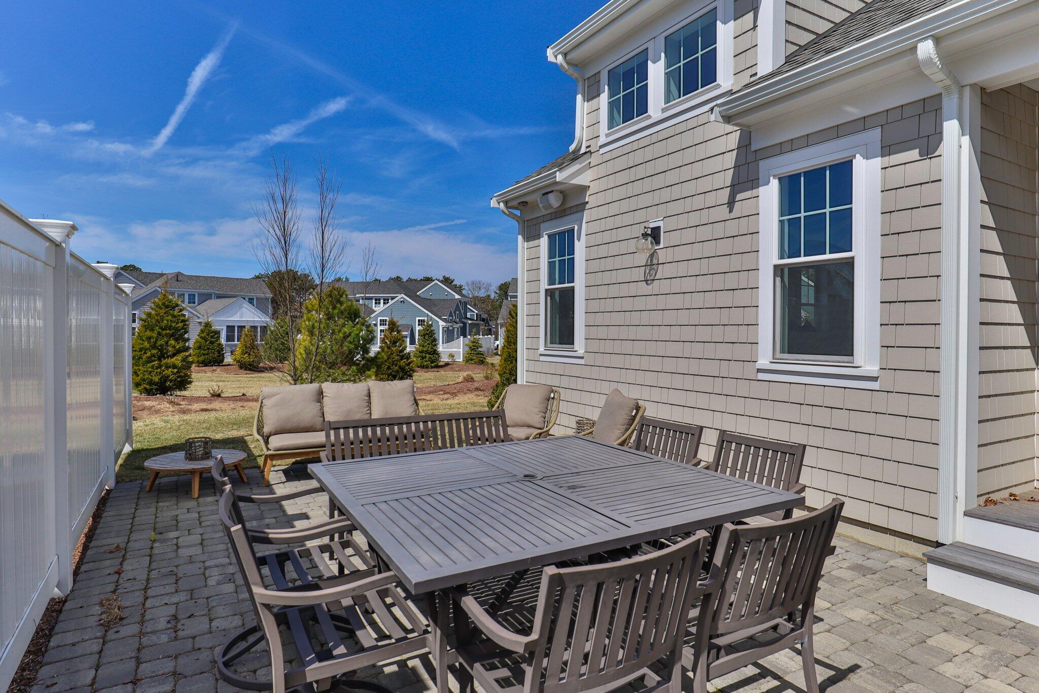 85 Cobblestone Circle Mashpee, MA 02649 - Photo 36 of 42 a view of a patio with table and chairs with wooden floor and fence