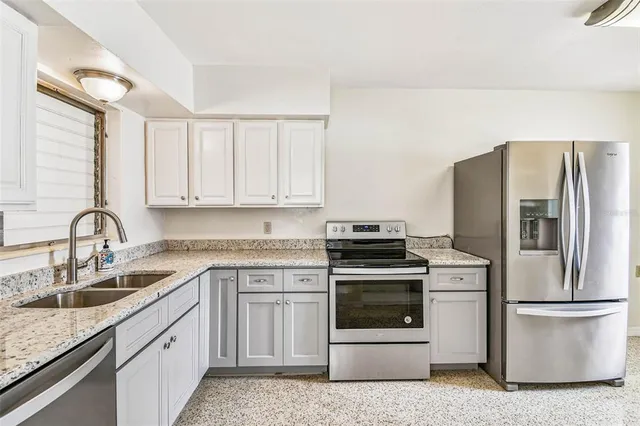 a kitchen with a sink stove and refrigerator