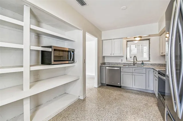 a kitchen with a sink and stainless steel appliances