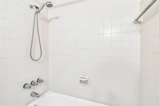a bathroom with a bath tub with a shower