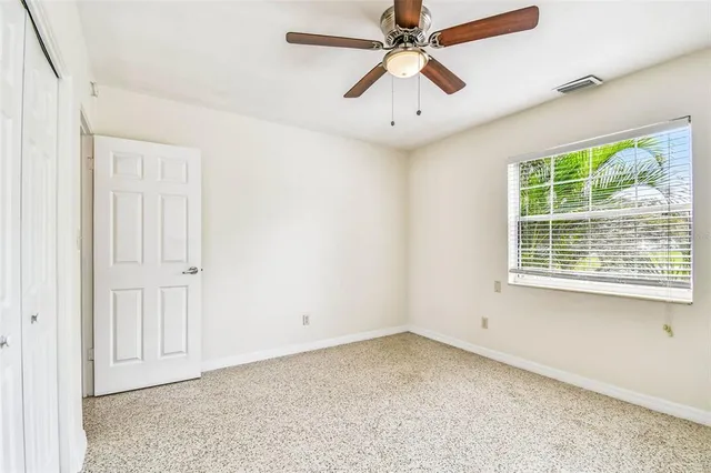 an empty room with a window and a fan