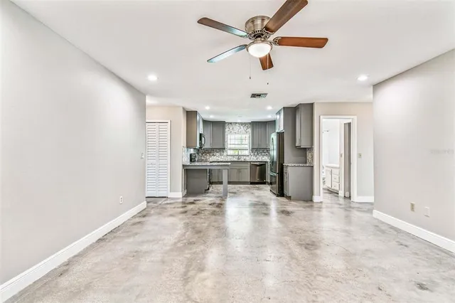 a kitchen with stainless steel appliances kitchen island a refrigerator sink and cabinets