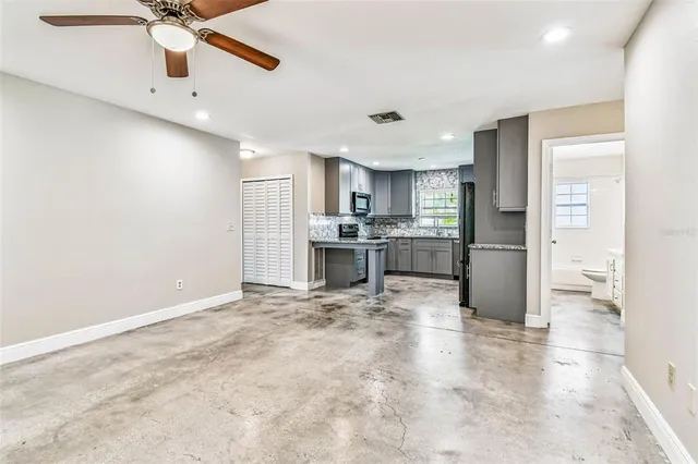 an empty room with a window and a ceiling fan