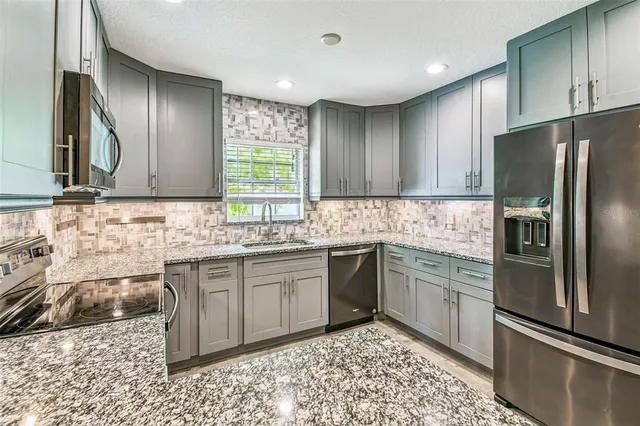 a kitchen with granite countertop a sink and a window