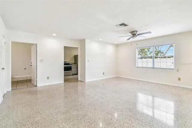 an empty room with fan and windows