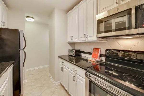 a kitchen with stainless steel appliances granite countertop a stove and a microwave