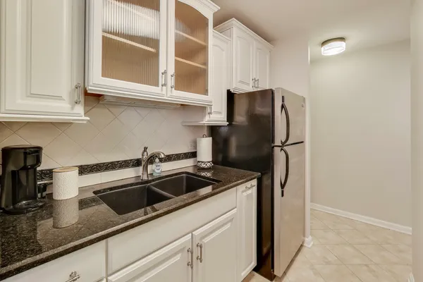 a kitchen with stainless steel appliances granite countertop a refrigerator and a sink