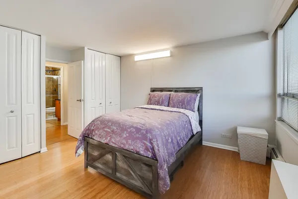 a spacious bedroom with a bed and wooden floor