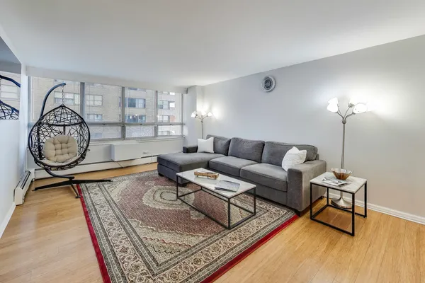 a living room with furniture a clock and a rug