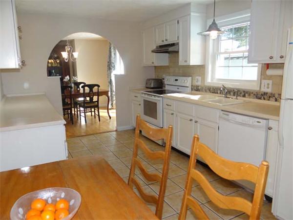 7 Burton Farm Drive Andover, MA 01810 - Photo 8 of 20 a kitchen with stainless steel appliances granite countertop a stove a sink a dining table and chairs with wooden floor
