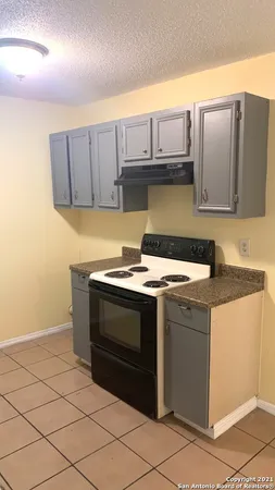 a stove top oven sitting inside of a kitchen