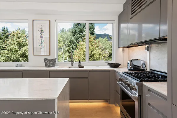 a kitchen with stainless steel appliances a sink a stove and a window