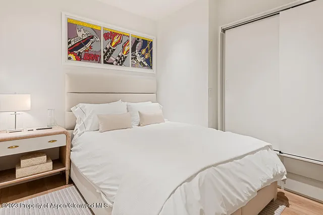 a bedroom with a bed and a painting on the wall