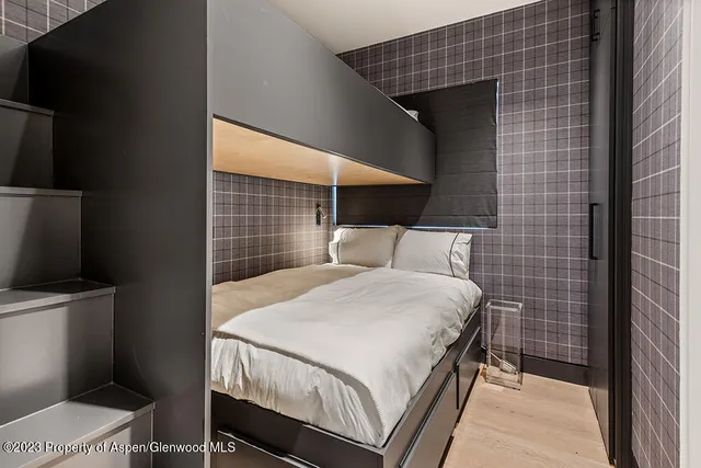 a bedroom with a bed and a flat tv screen on the wall