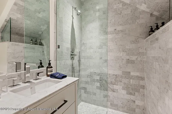 a bathroom with a sink shower and a mirror