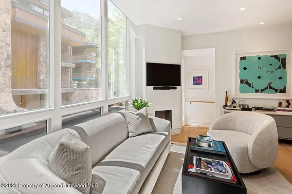 a living room with furniture a flat screen tv and a large window