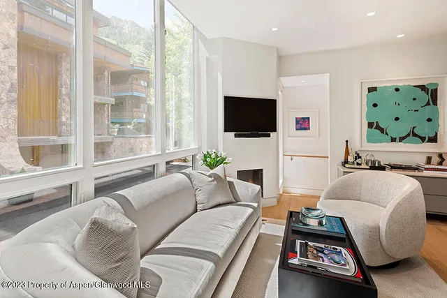 a living room with furniture a flat screen tv and a large window