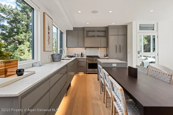 a kitchen with kitchen island granite countertop a sink a counter top space and living area