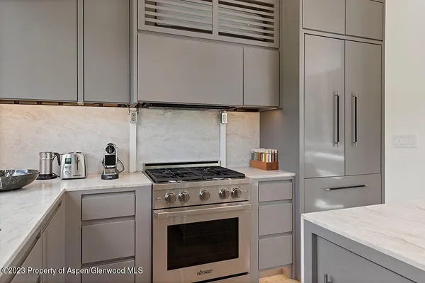a kitchen with stainless steel appliances granite countertop a stove a sink and a refrigerator