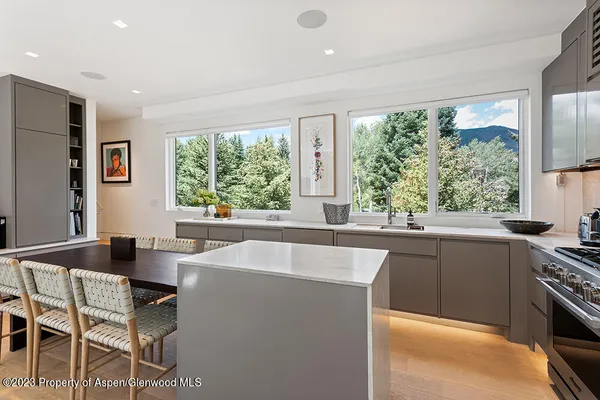 a kitchen with a table chairs sink and cabinets