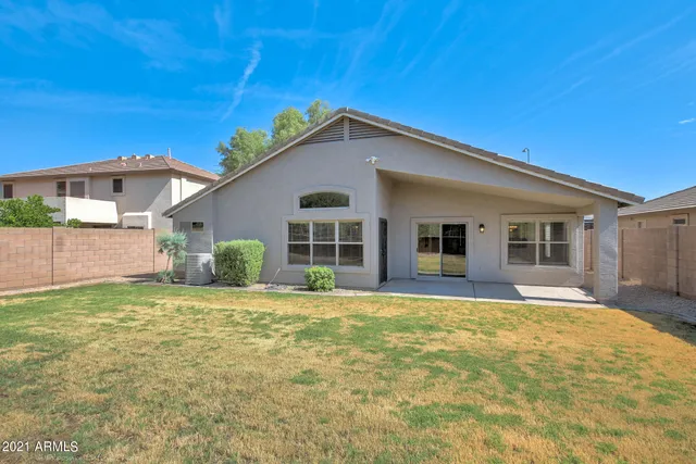 a view of a yard in front of a house with a large tree