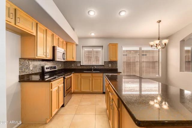 a kitchen with stainless steel appliances granite countertop a stove a sink and a refrigerator