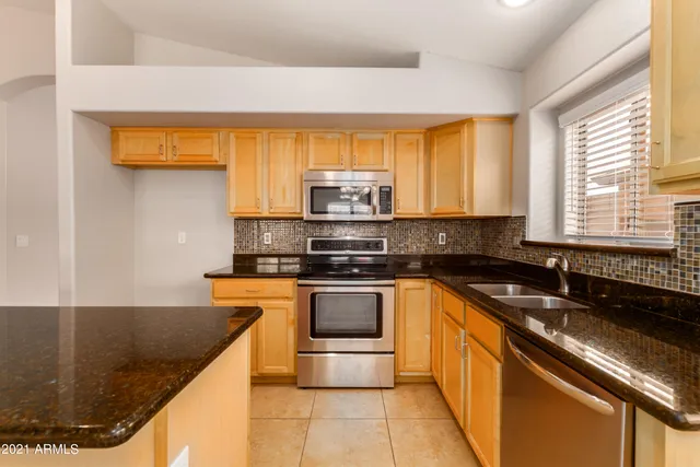 a kitchen with stainless steel appliances granite countertop a sink stove and cabinets