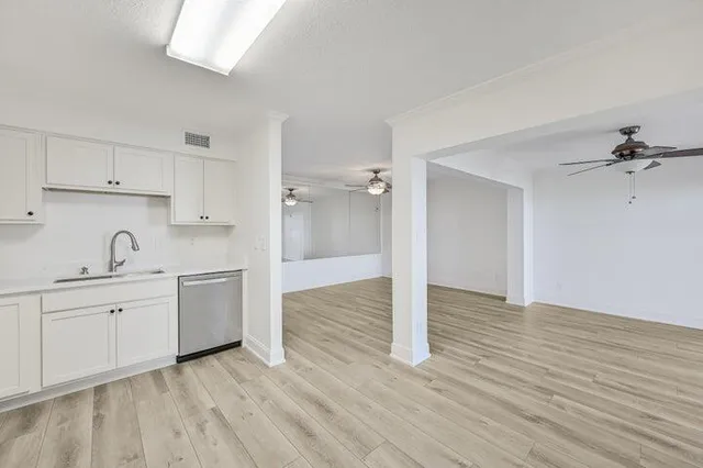 a view of a kitchen with wooden floor cabinets and a sink