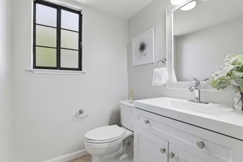 a bathroom with a sink mirror vanity and toilet