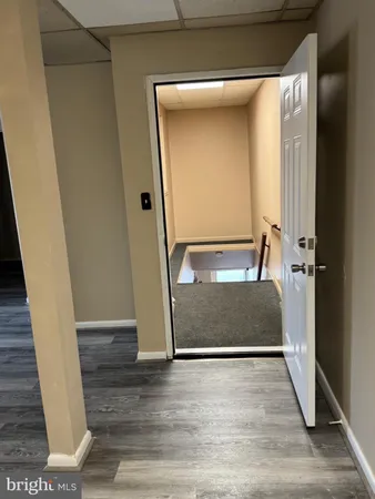 a view of an empty room with wooden floor and closet