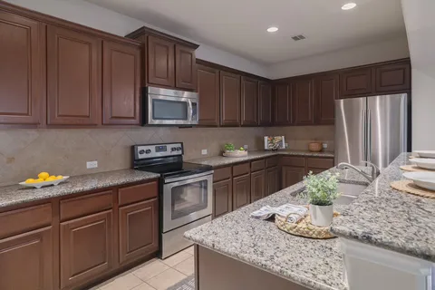a kitchen with granite countertop stainless steel appliances stove and cabinets