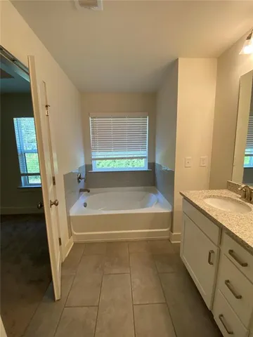 a bathroom with a tub sink and a mirror