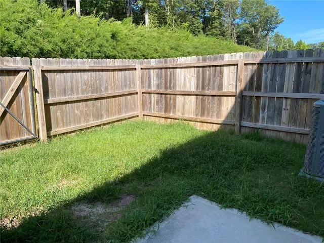 a view of a backyard with wooden fence