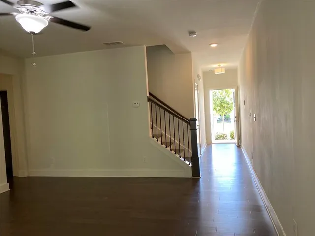 a view of a hallway with wooden floor and chandelier