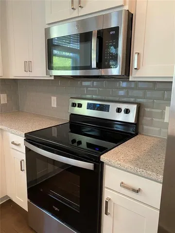 a stove top oven sitting inside of a kitchen