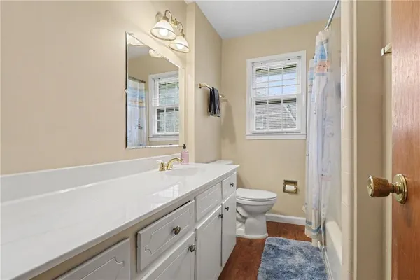 a bathroom with a sink a toilet and a mirror