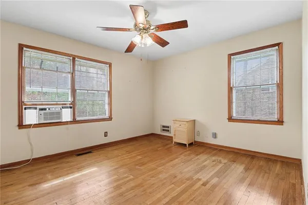 an empty room with a window and a ceiling fan