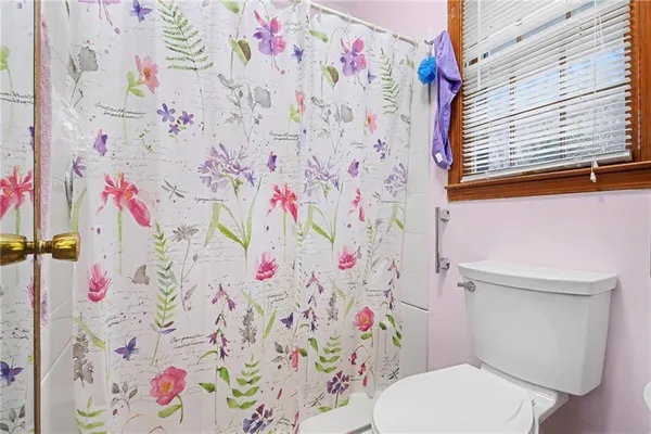 a white toilet sitting next to a shower curtain