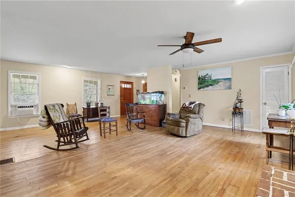 a dining room with wooden floor and windows