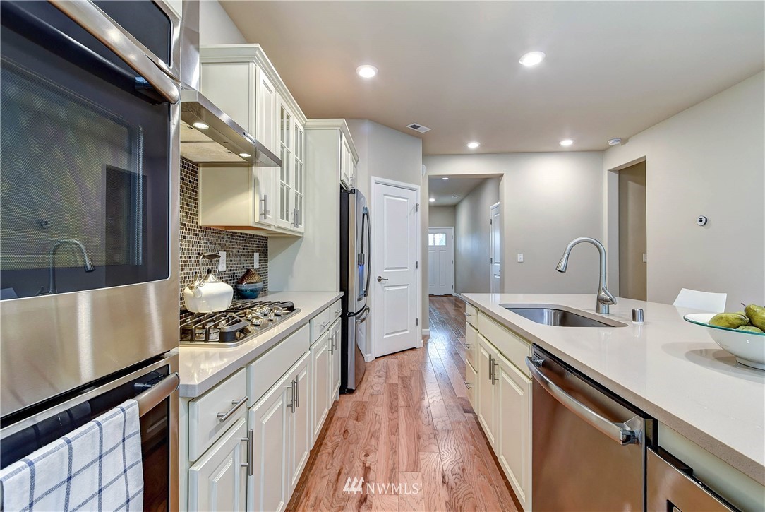 21323 42nd Avenue Southeast Bothell, WA 98021 - Photo 6 of 16 a kitchen with stainless steel appliances granite countertop a sink stove and cabinets