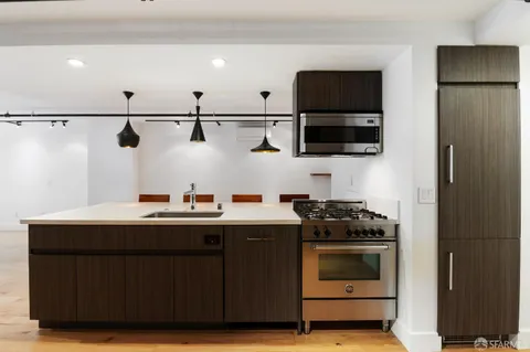 a kitchen with stainless steel appliances a stove and a microwave