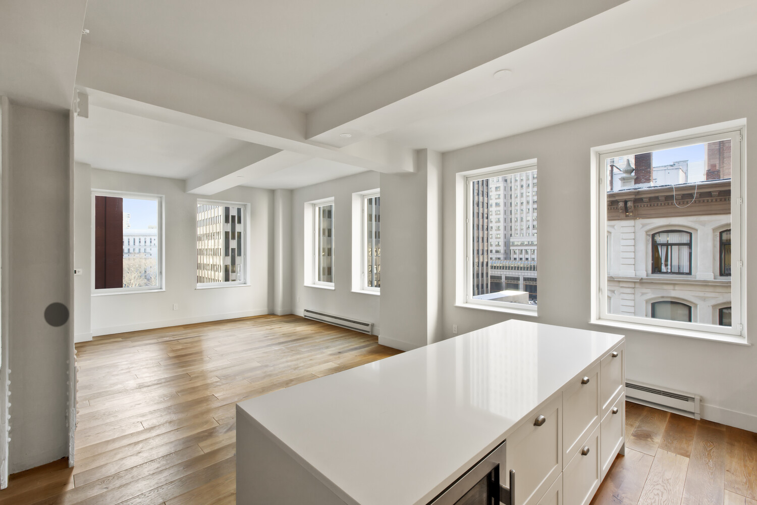 93 Worth Street, Unit 602 Manhattan, NY 10013 - Photo 2 of 8 a living room with stainless steel appliances kitchen island a large window and wooden floor