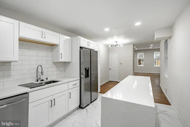 a kitchen with a sink dishwasher a refrigerator and cabinets