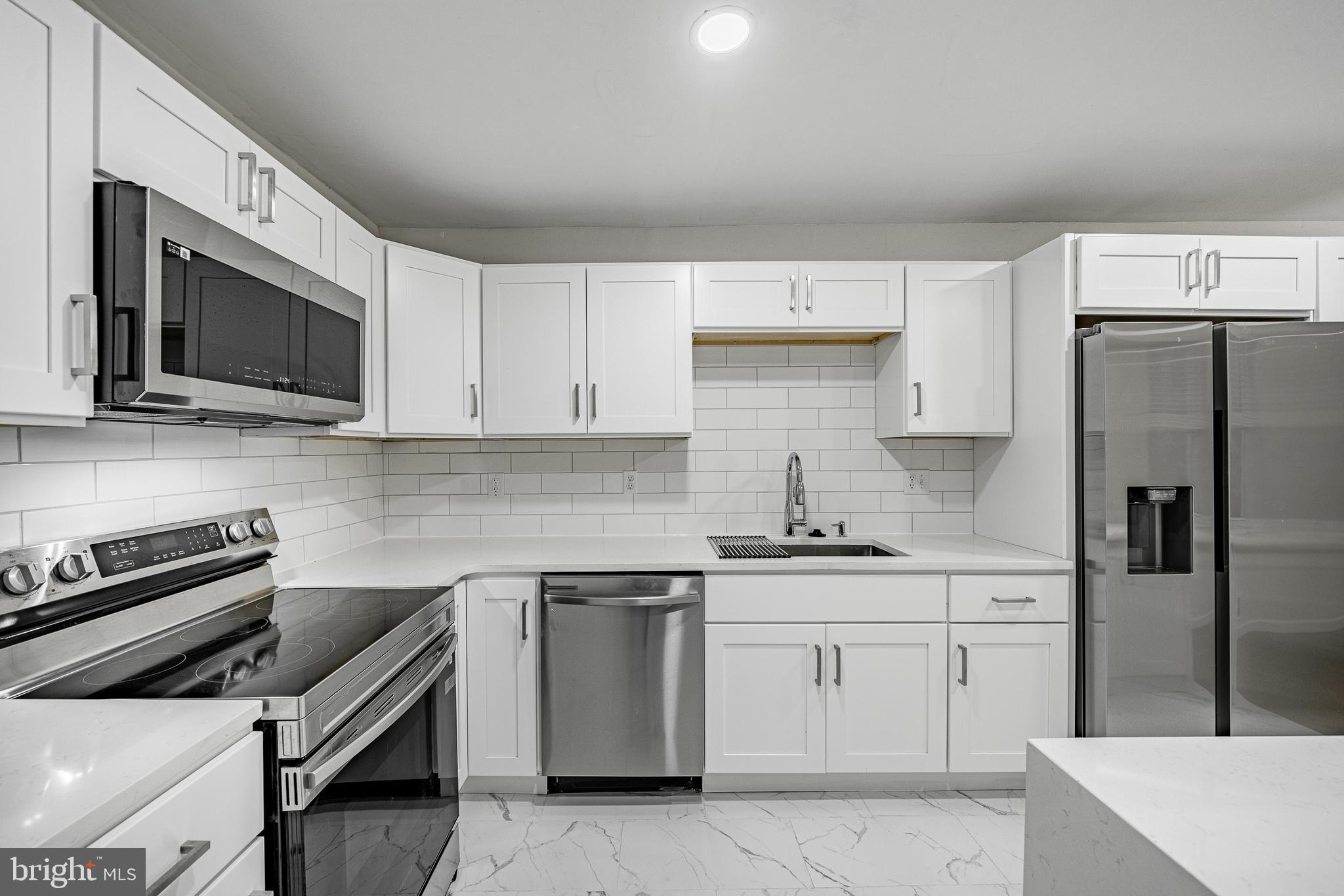 841 Perkiomen Street Philadelphia, PA 19130 - Photo 8 of 23 a kitchen with a sink stove and white cabinets