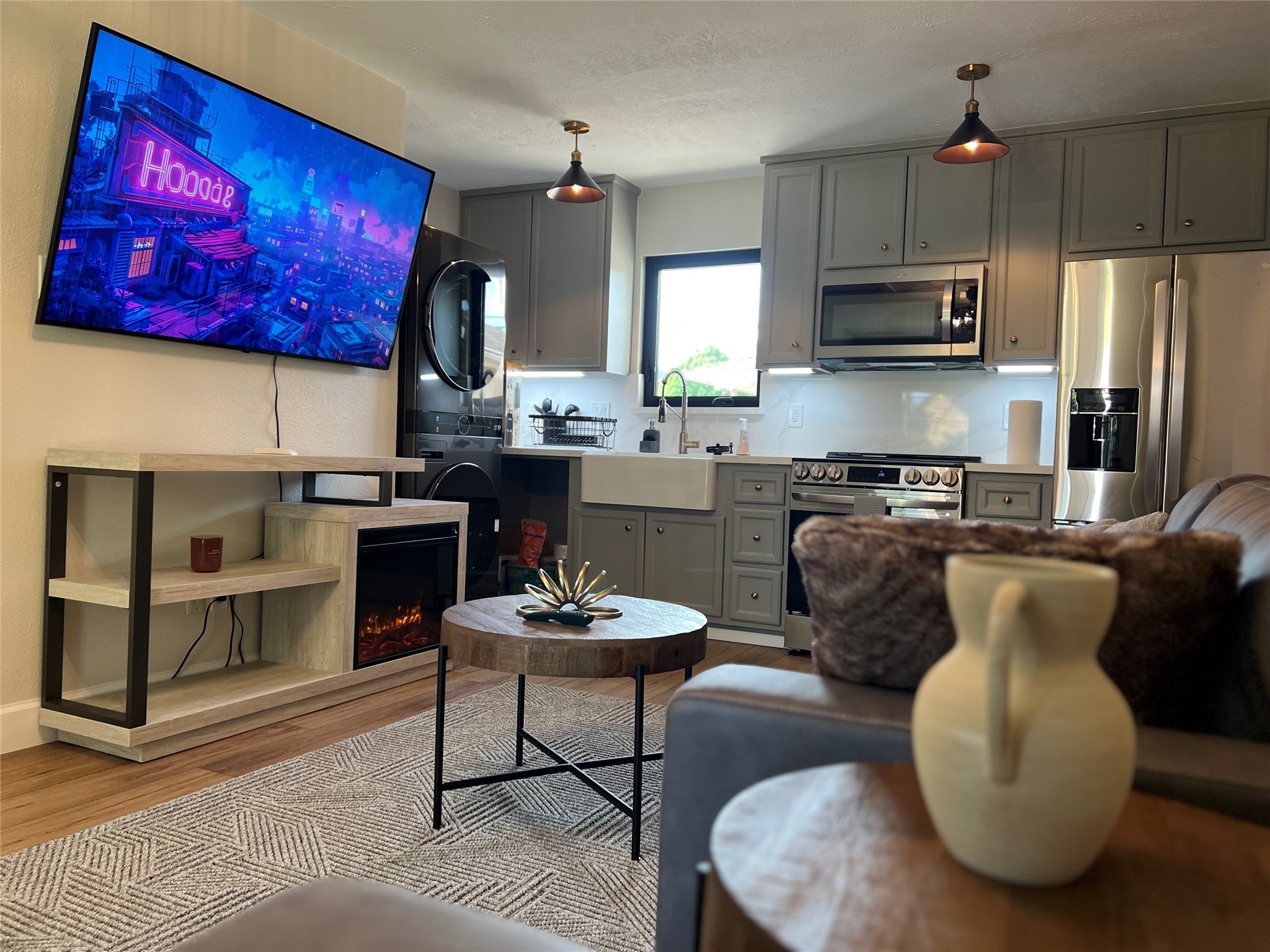 a kitchen with stainless steel appliances granite countertop a stove top oven a sink dishwasher a dining table and chairs with wooden floor