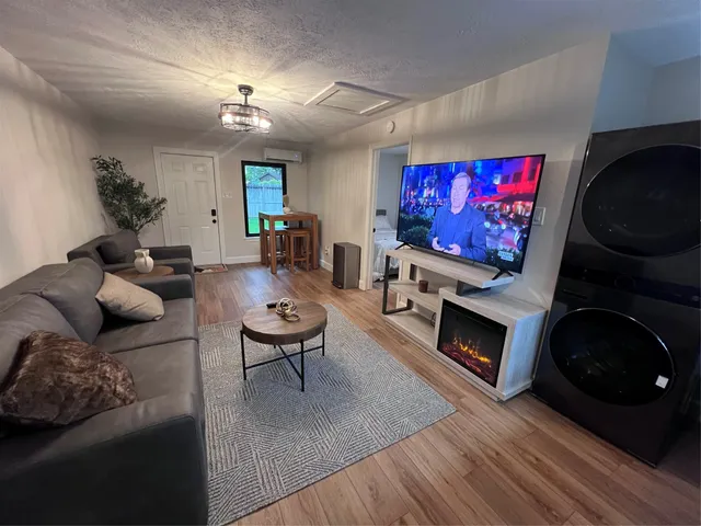 a living room with furniture a flat screen tv and a fireplace